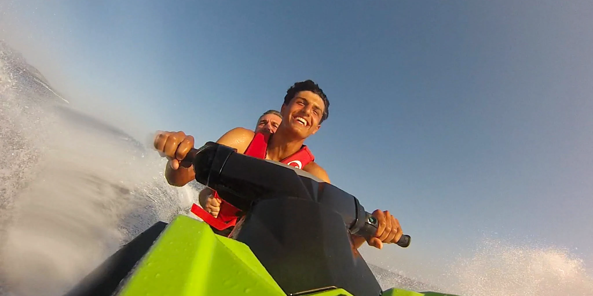 Pilote bras ouverts sur un jet ski au-dessus d'une eau turquoise à Fréjus
